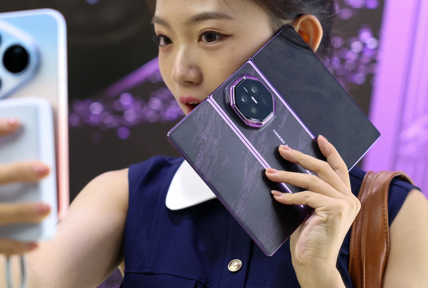 An audience member takes a selfie with Huawei's Mate XT 2 tri-fold smartphone powered by the new Kirin 9050 Pro chip after a launch event in Guangzhou, south China's Guangdong Province, Sept. 7, 2026. Chinese tech giant Huawei on Monday launched the Mate XT 2 tri-fold smartphone powered by the new Kirin 9050 Pro chip, the first high-performance processor to use logic folding technology.  The Kirin 9050 Pro stacks logic units in layers within a single chip, shortening signal transmission paths, reducing latency and boosting overall performance, according to a launch event in Guangzhou.  The last time Huawei introduced a new Kirin chip at a flagship launch was at the global release of the Mate 40 smartphone six years ago. The company has continued to innovate and break new ground in recent years. (Photo by Mao Siqian/Xinhua via Getty Images)
