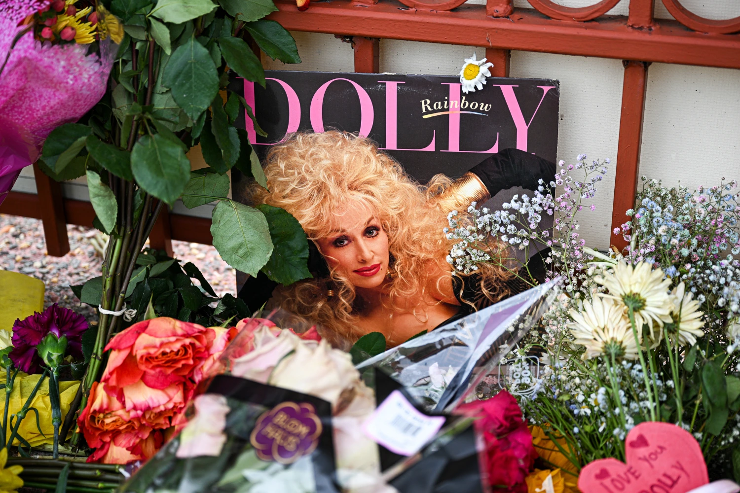 Flowers and notes are left outside Dolly Parton's studio on Elmwood Street in Nashville, Tennessee, on August 26, 2026.