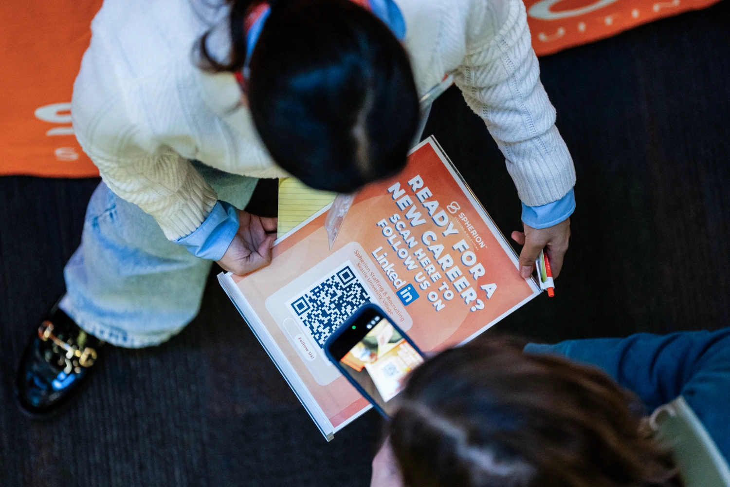 A jobseeker scans a QR code while speaking to a recruiter during the WorkSource North Seattle Career Fair in Seattle, Washington, US, on Tuesday, Feb. 10, 2026.