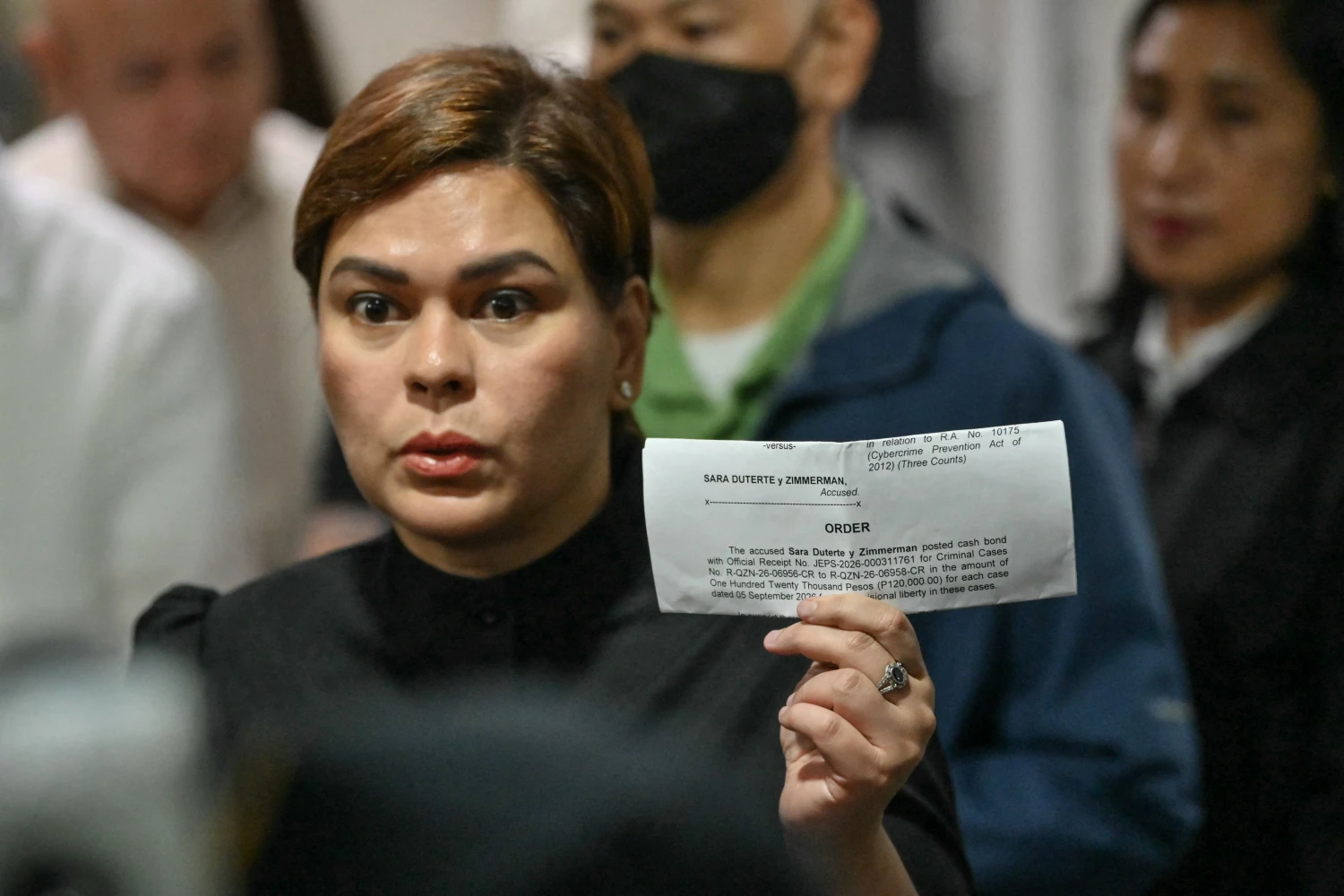 Philippine Vice President Sara Duterte shows a document after posting bail at a court building in Quezon City suburban Manila on Sept. 5.