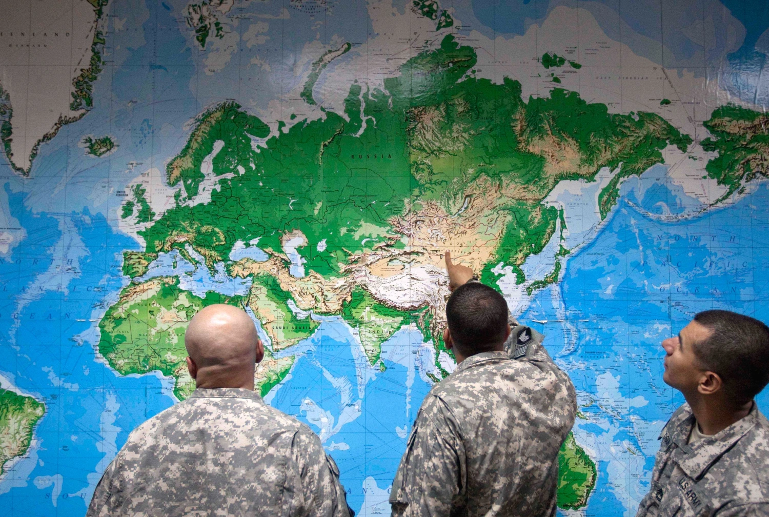 Soldiers look at a world map as they wait to board a flight in Manas, Kyrgyzstan, on the way home after completing a deployment in Afghanistan, in August 2011.