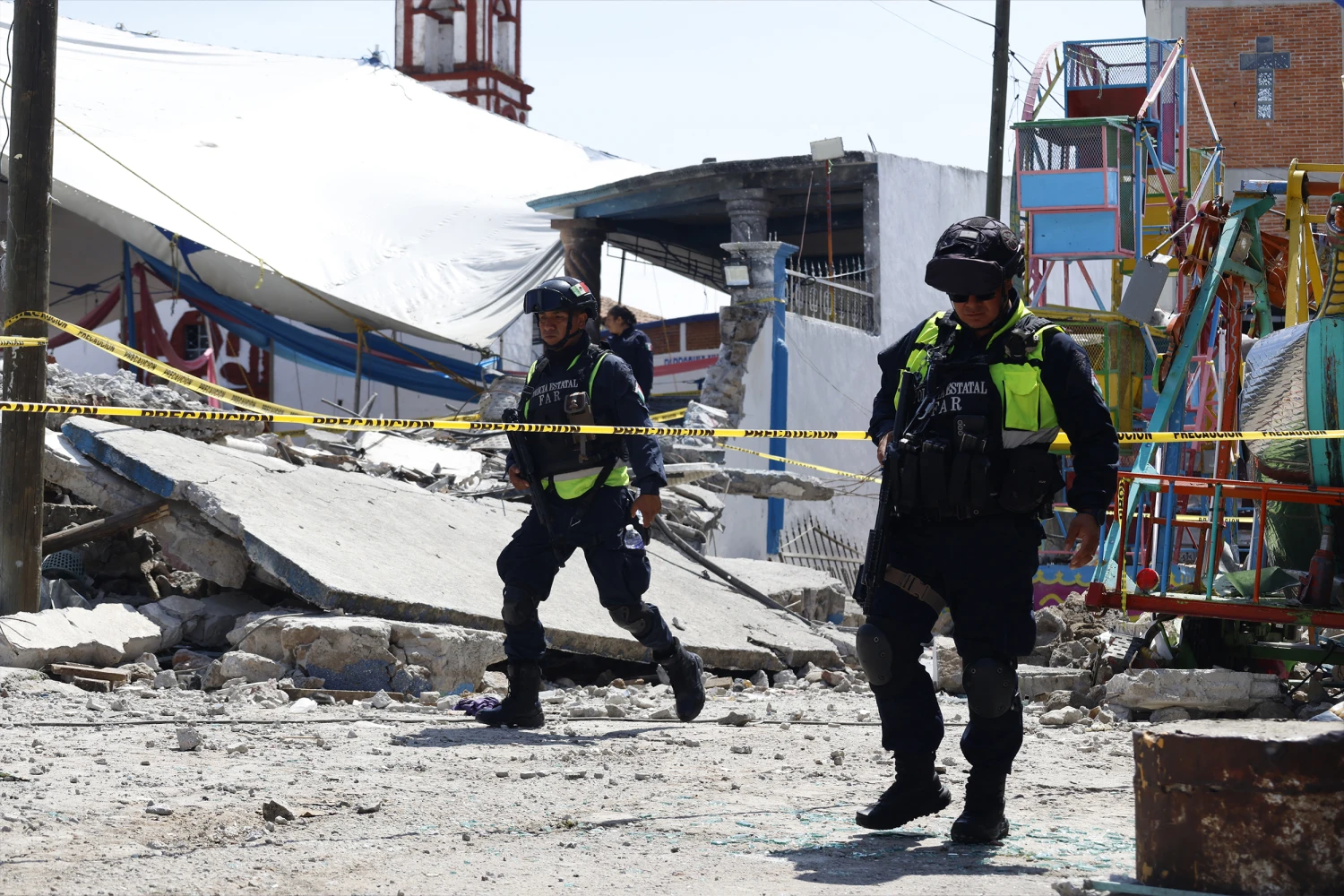 Mexico State Police officers inspect the site of a fireworks blast at a church Saturday while hundreds of people were celebrating a patron saint's festival.