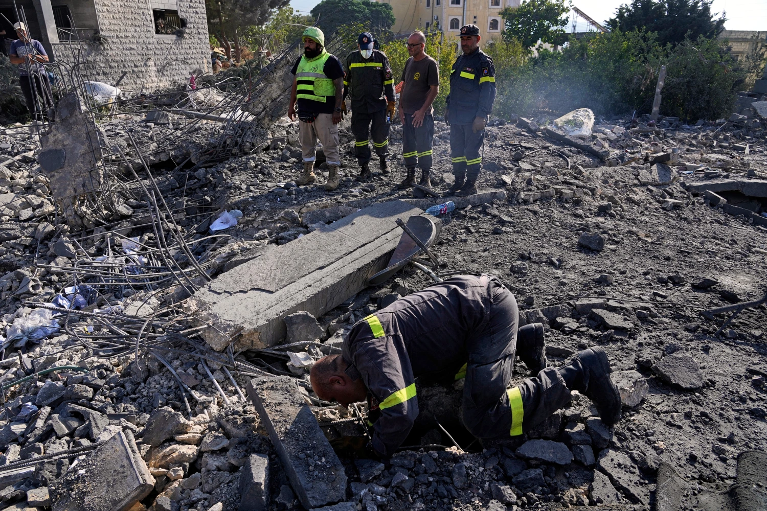 Rescue workers search for victims under the rubble of a building destroyed in an Israeli airstrike in the southern village of Kfar Rumman, Lebanon, Monday, Sept. 7, 2026. (AP Photo/Mohammed Zaatari)