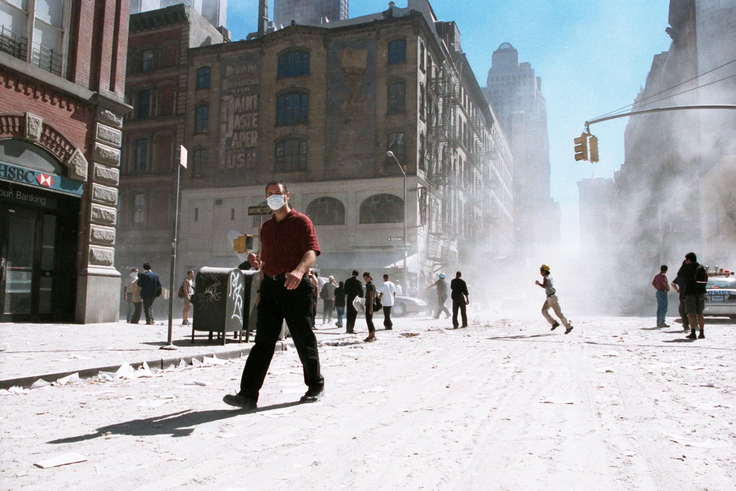 An unidentified man with a face mask walks on an ash covered street near Ground Zero after the collapse of the Twin Towers September 11, 2001 in New York City. The World Trade Center's Twin Towers and the Pentagon were attacked by terrorists using commercial airliners as missiles.