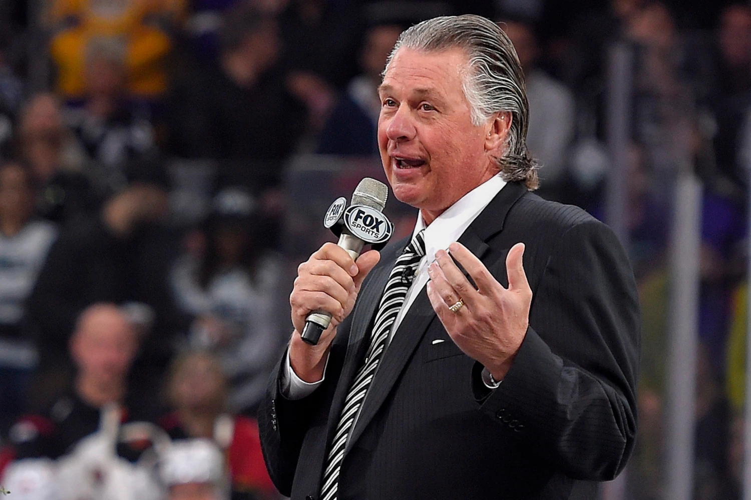 FILE - Former Los Angeles Kings coach Barry Melrose speaks to fans as he is honored prior to an NHL hockey game between the Kings and the Calgary Flames, on Feb. 12, 2015, in Los Angeles.