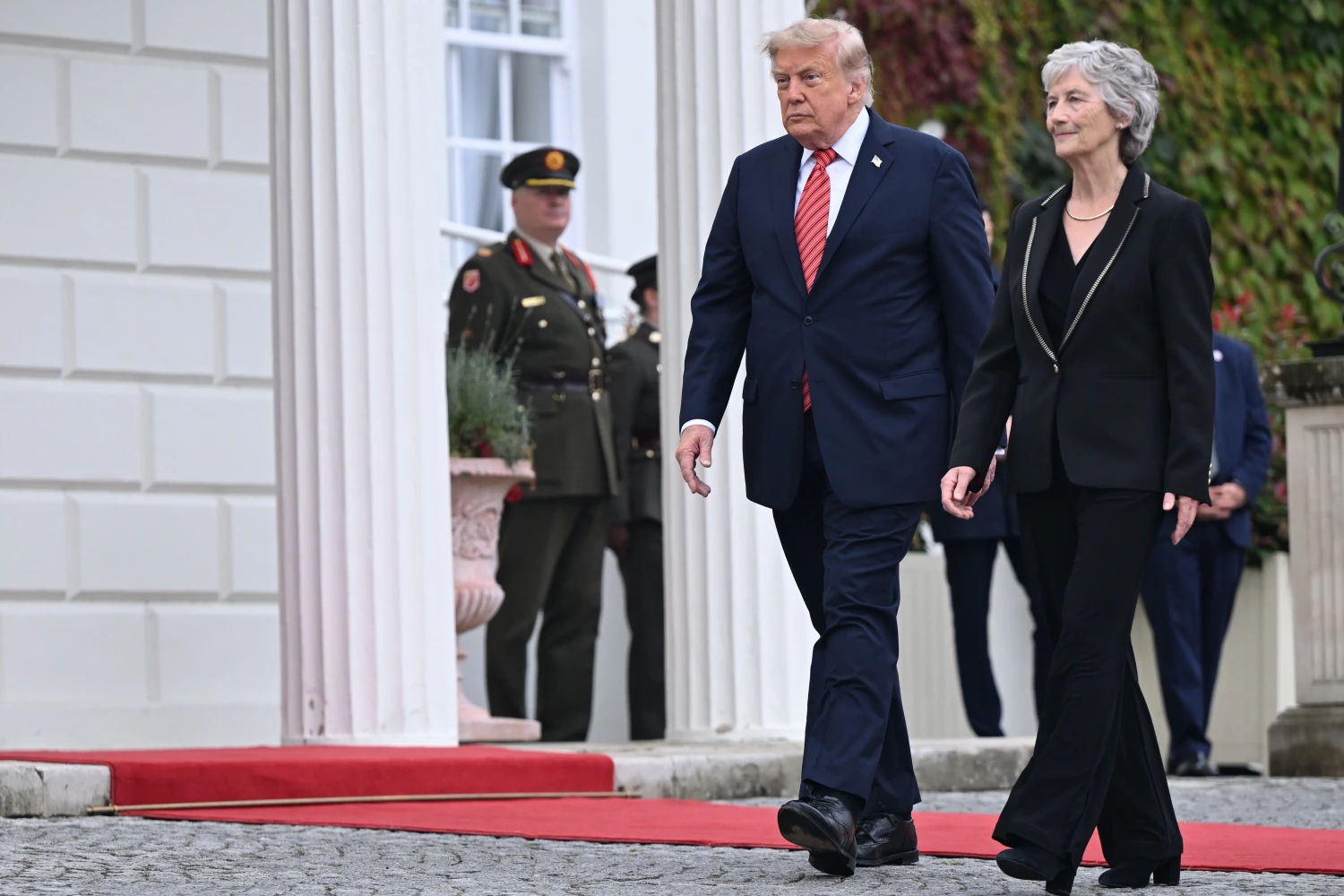 U.S. President Donald Trump walks alongside Irish President Catherine Connolly during arrival events at Áras an Uachtaráin on September 12, in Dublin, Ireland.