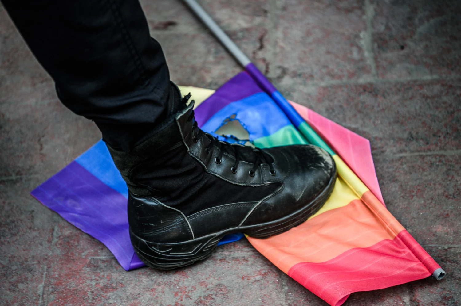 A Turkish anti-riot police officer steps on a rainbow flag during a rally staged by the LGBT community in Istanbul on June 19, 2016.