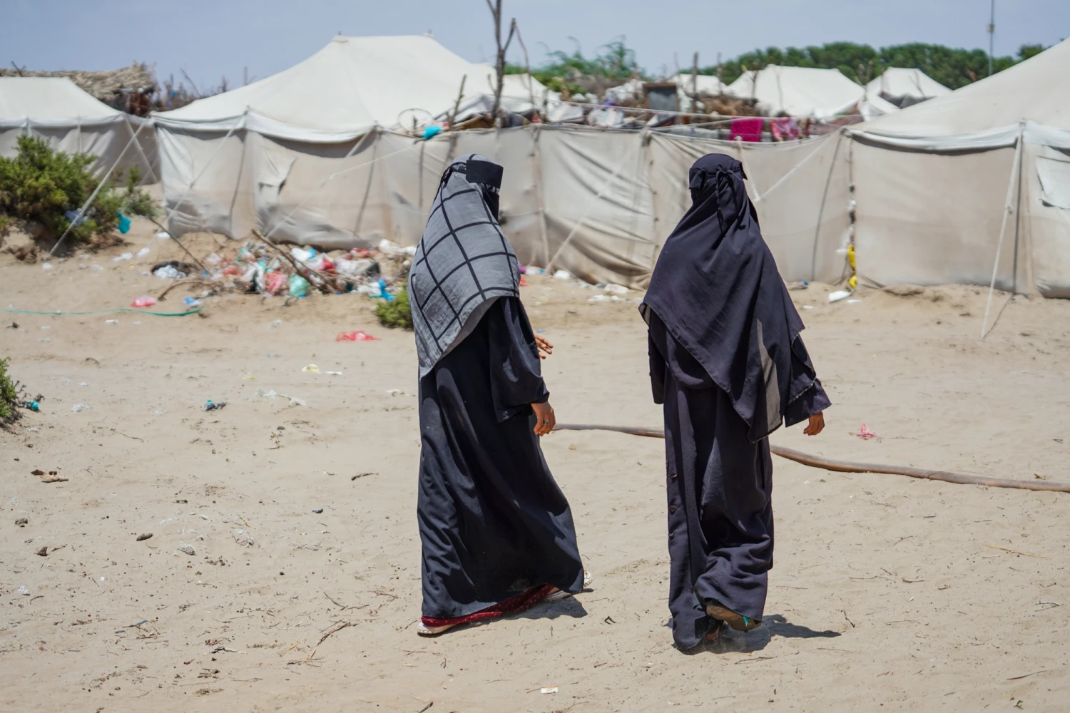 Displaced Yemenis from Al Khawkhah city walk past their temporary shelter in Aden, Yemen, on Sept. 13, 2026.