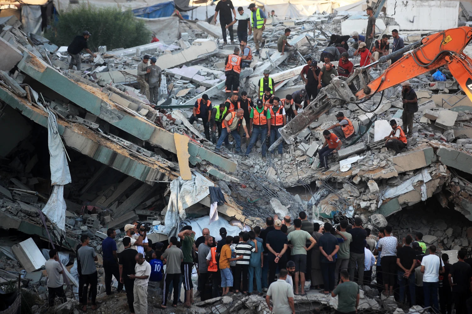 Civil defense workers attempt to rescue people trapped beneath the rubble of a residential building in Gaza City, on Wednesday. The building collapsed after being damaged in an Israeli strike during the war.