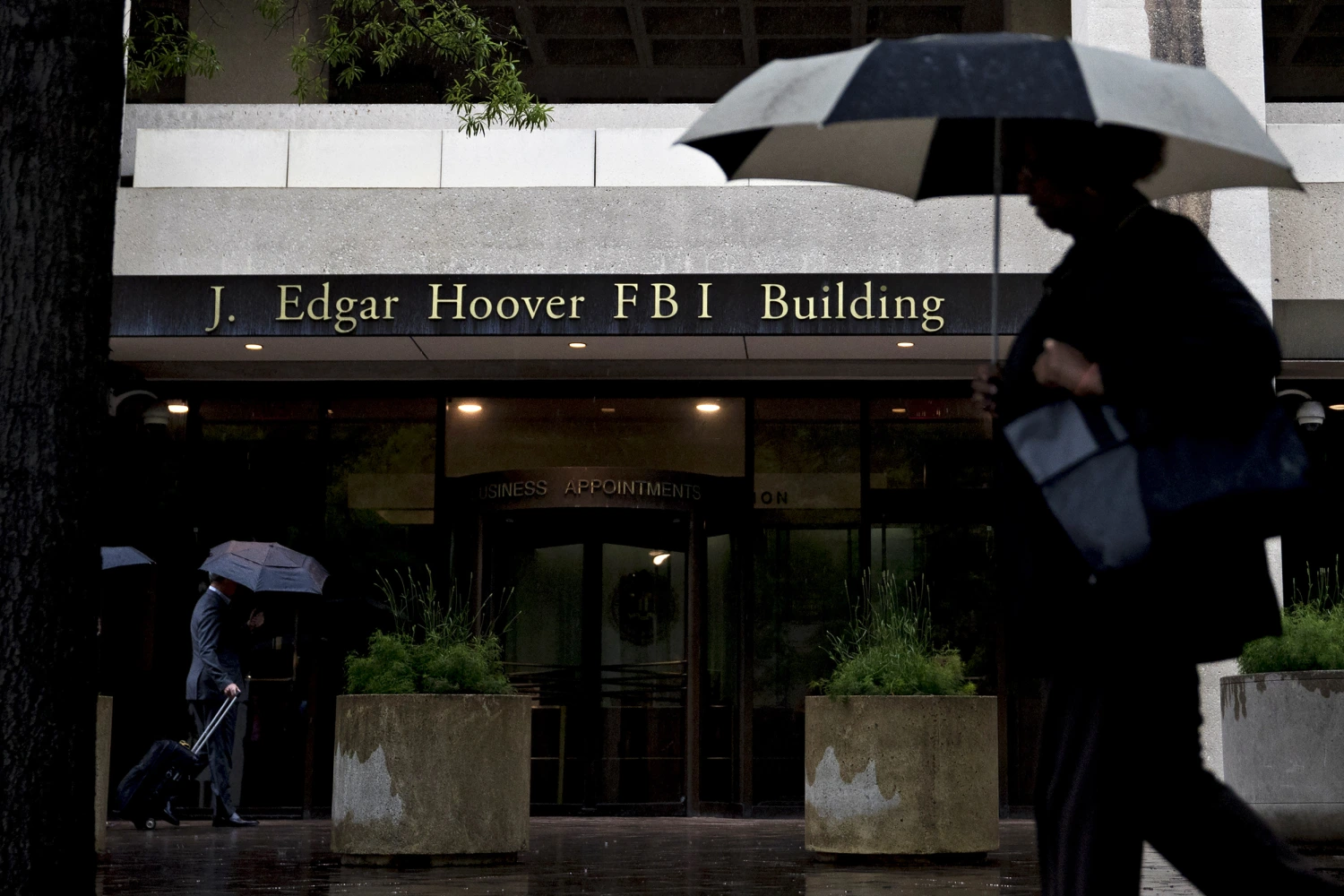 A pedestrian walks with an umbrella past the Federal Bureau of Investigation (FBI) headquarters in Washington, D.C., U.S., on Thursday, May 11, 2017.