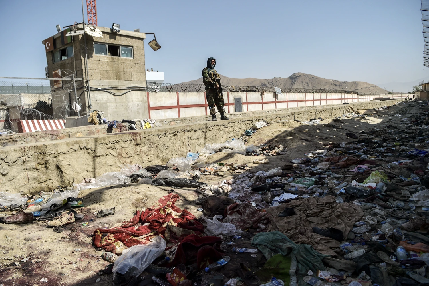 A Taliban fighter stands guard at the site of the August 26 twin suicide bombs, which killed scores of people including 13 US troops, at Kabul airport on August 27, 2021.