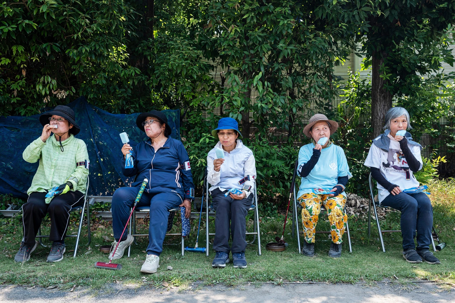 This photo taken on July 27, 2023 shows senior citizens enjoying cool popsicles after playing the croquet-inspired game of "gateball" at a park in suburban Tokyo, as temperatures of 36C-plus (97F) scorched the Japanese capital.