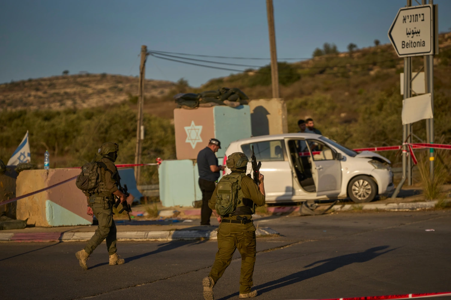Israeli security forces inspect the scene where, according to police, a Palestinian man was shot and killed after ramming his car into a security checkpoint and seriously wounding an officer, near the West Bank Jewish settlement of Beit Horon, Wednesday, Sept. 23, 2026.