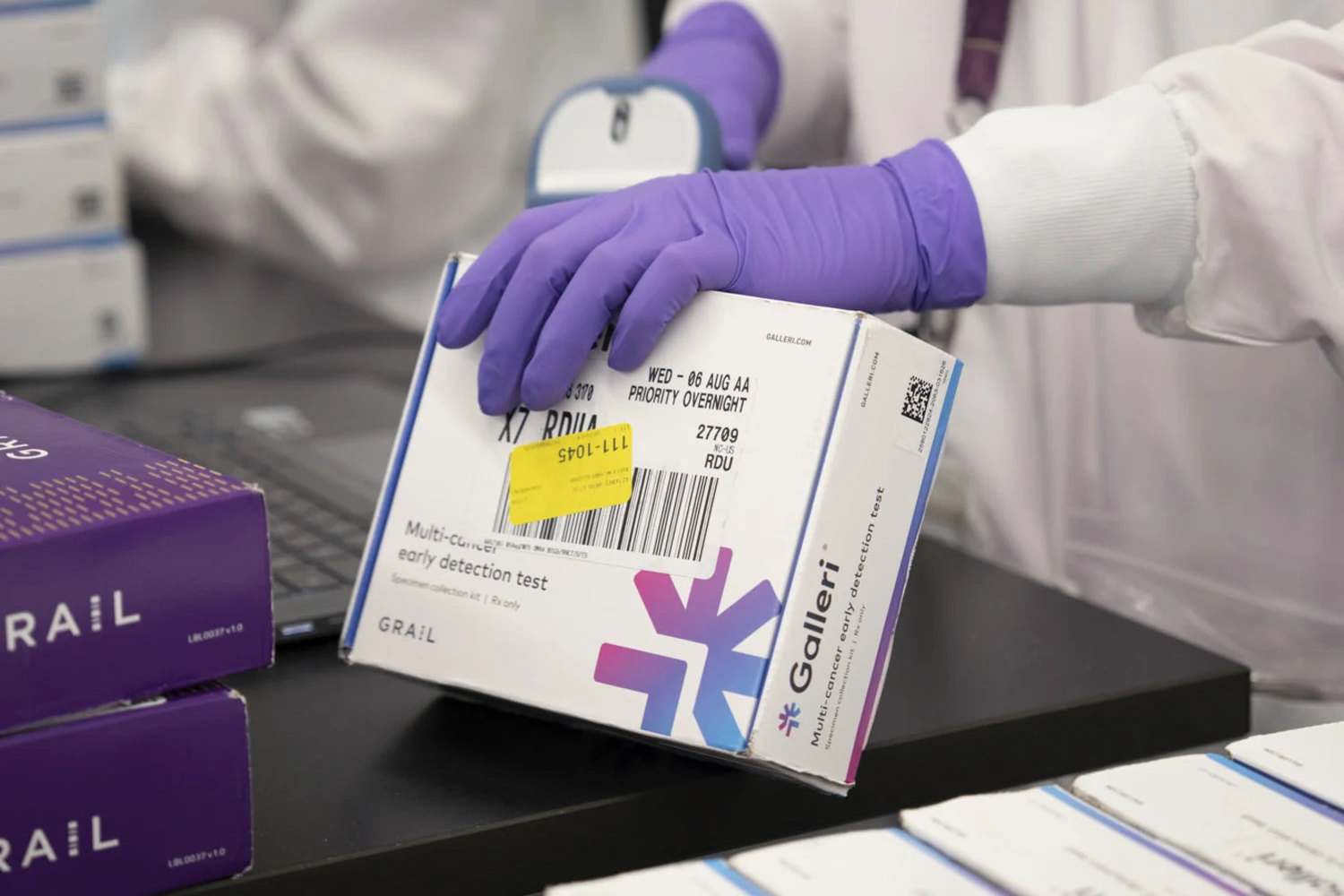An employee scans a Galleri cancer early detection test.