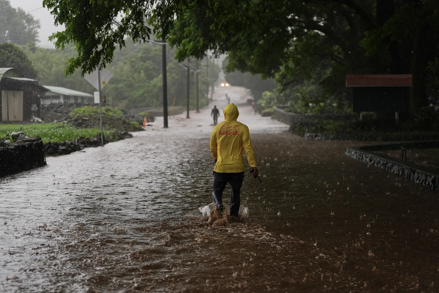 Fire Captain Lui Sales of the Hawaii Fire Department looks for residents to help as rainwater from nearby Hurricane Nolo flood a section of Mamalahoa highway Saturday, Sept. 26, 2026, near Naalehu, Hawaii.