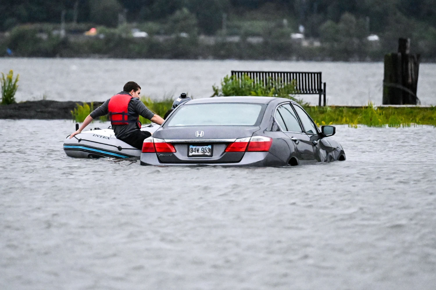 A person is seen on a boat near a vehicle submerged in floodwaters in a parking lot along the Hudson River during a nor'easter storm in Edgewater, N.J., on Sept. 26, 2026. Heavy rain and strong winds battered the northeastern United States as an unusually powerful autumn storm intensified, forcing the cancellation of hundreds of flights and leaving tens of thousands of people without power. New York, Boston and Philadelphia were among the areas affected by the storm, as authorities warned of potential major flooding and road closures.