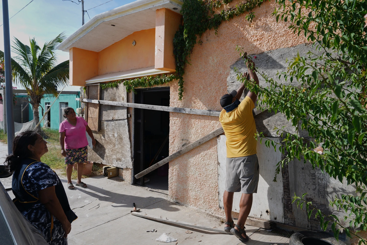 A man boards up a house's windows as Hurricane Polo approaches in Puerto San Carlos, Baja California Sur state, Mexico, Sunday, Sept. 27, 2026.