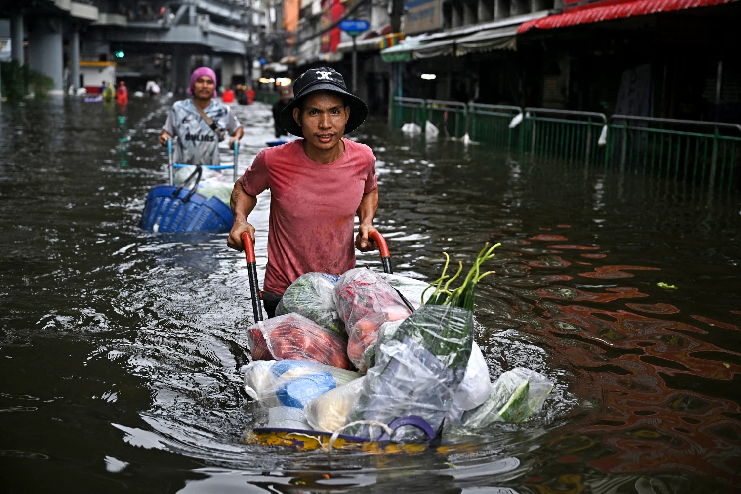 Vendors transport produce through floodwaters in Bang Kapi district in Bangkok on September 28, 2026.