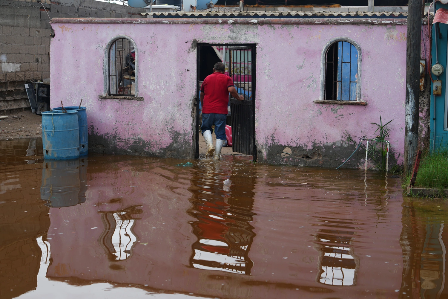 A resident enters his home surrounded by water brought by Hurricane Polo in Puerto San Carlos, Baja California Sur state, Mexico, Tuesday, Sept. 29, 2026.