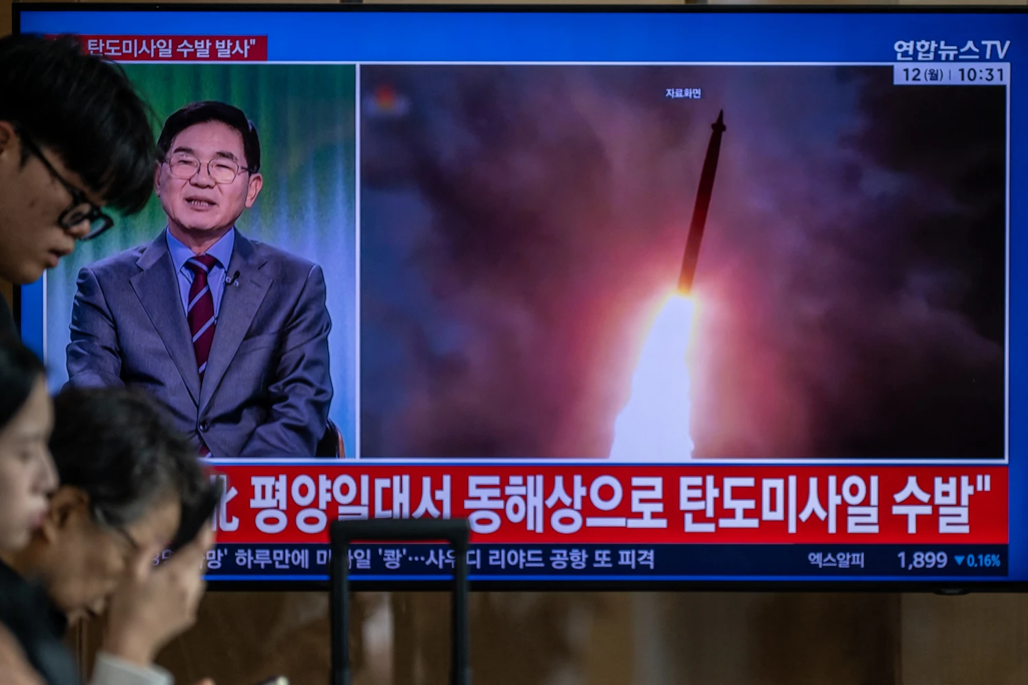 TOPSHOT - News coverage showing file footage of a North Korean missile launch is seen on a screen at Seoul Station in Seoul on October 12, 2026. North Korea on October 12 fired multiple ballistic missiles off its east coast, Seoul's military said, after weeks of mounting friction over a landmine explosion along the countries' heavily fortified border. (Photo by Philip FONG / AFP via Getty Images)