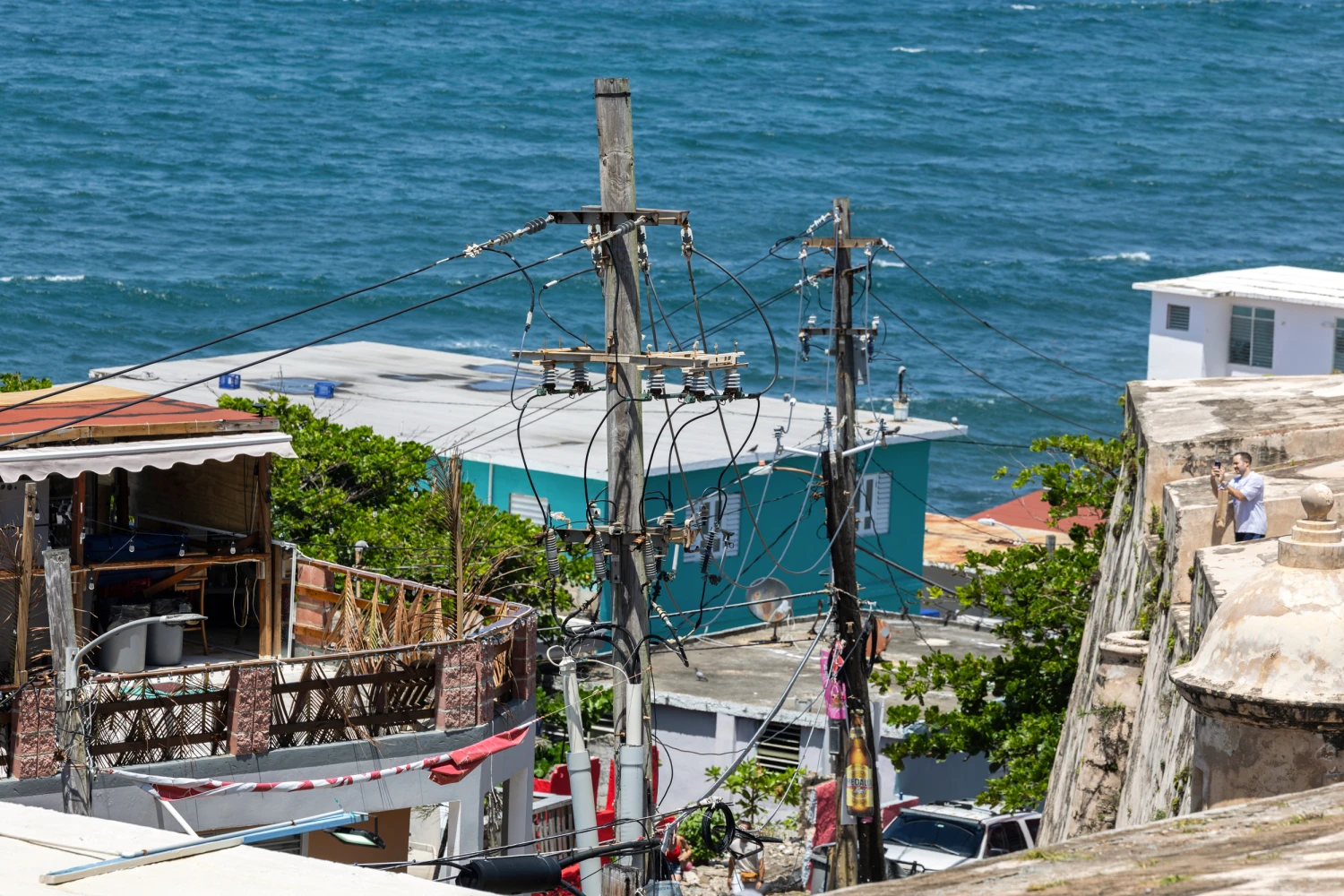 Power lines and utility poles stand in front of La Perla neighborhood along the coast in Old San Juan, Puerto Rico, Aug. 15, 2025.