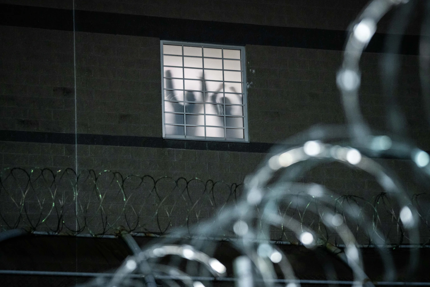 Detainees stand by a window at Delaney Hall, an ICE facility in Newark, N.J., on May 26, 2026.