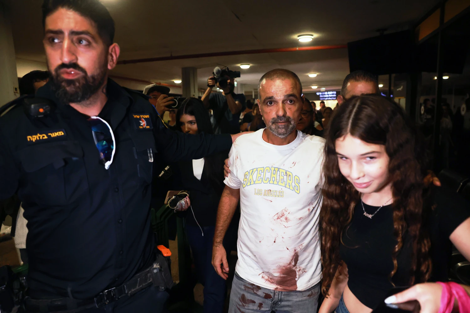 Israeli passenger Yaniv Hayoun, with blood stains on his shirt, who was aboard a Flydubai aircraft that made an emergency landing in Saudi Arabia, is welcomed at the arrivals gate at Ben Gurion International Airport near Tel Aviv, Israel, Wednesday, Sept. 30, 2026.
