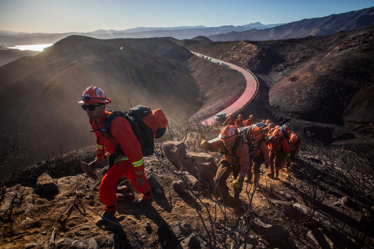Inmate firefighters from the Growlersburg crew hike up the mountain to create a containment fire line to control the Hughes Fire in Castaic, a northwestern neighborhood of Los Angeles County, Calif., on Jan., 23, 2025.