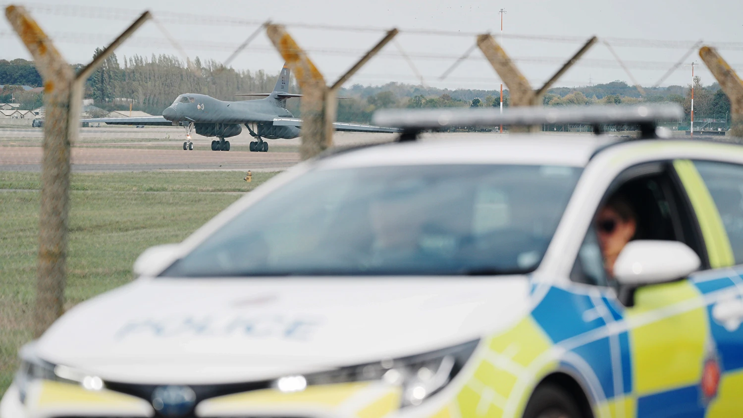 Police patrol the perimeter of RAF Fairford as a US Air Force Rockwell B-1 Lancer bomber lands on Sept. 28, 2026.