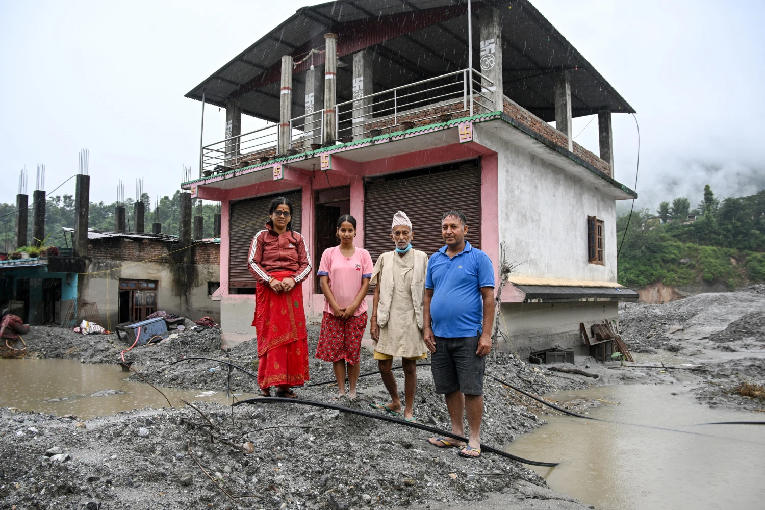 Residents of Nepal's Nuwakot district in front of their damaged shop on September 25, 2026, following the August flash floods. The Himalayan nation suffered one of the worst catastrophes in its history.