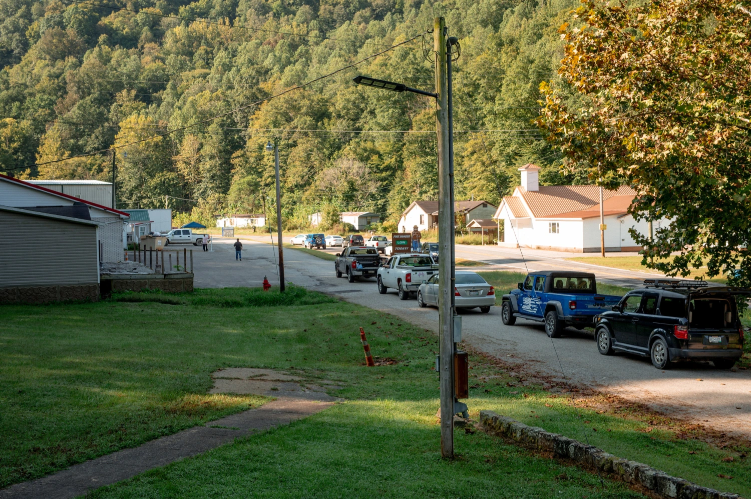 A line of cars wait to receive donated food during a weekly drive-up food pantry in Dunlow, West Virignia.