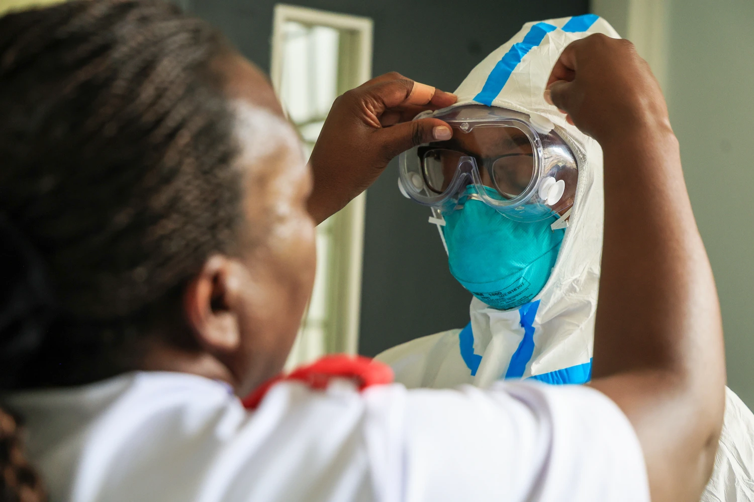 A health worker helps a colleague to put on a Personal Protective Equipment (PPE) in a room at an Ebola isolation facility at The Nairobi Hospital, Kenya, Wednesday, Oct. 7, 2026.