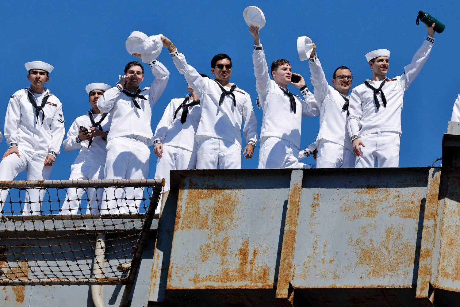 Sailors aboard the USS Abraham Lincoln Nimitz-class aircraft carrier wave to friends and family members as the ship docks at its homeport at Naval Air Station North Island on return from a historic 10-month deployment on Oct. 8, 2026, in Coronado, Calif. The USS Abraham Lincoln (CVN 72) set a U.S. Navy record spending over 260 days consecutively at sea without a port call while playing a key role in Operation Epic Fury and regional maritime security operations in the Middle East.