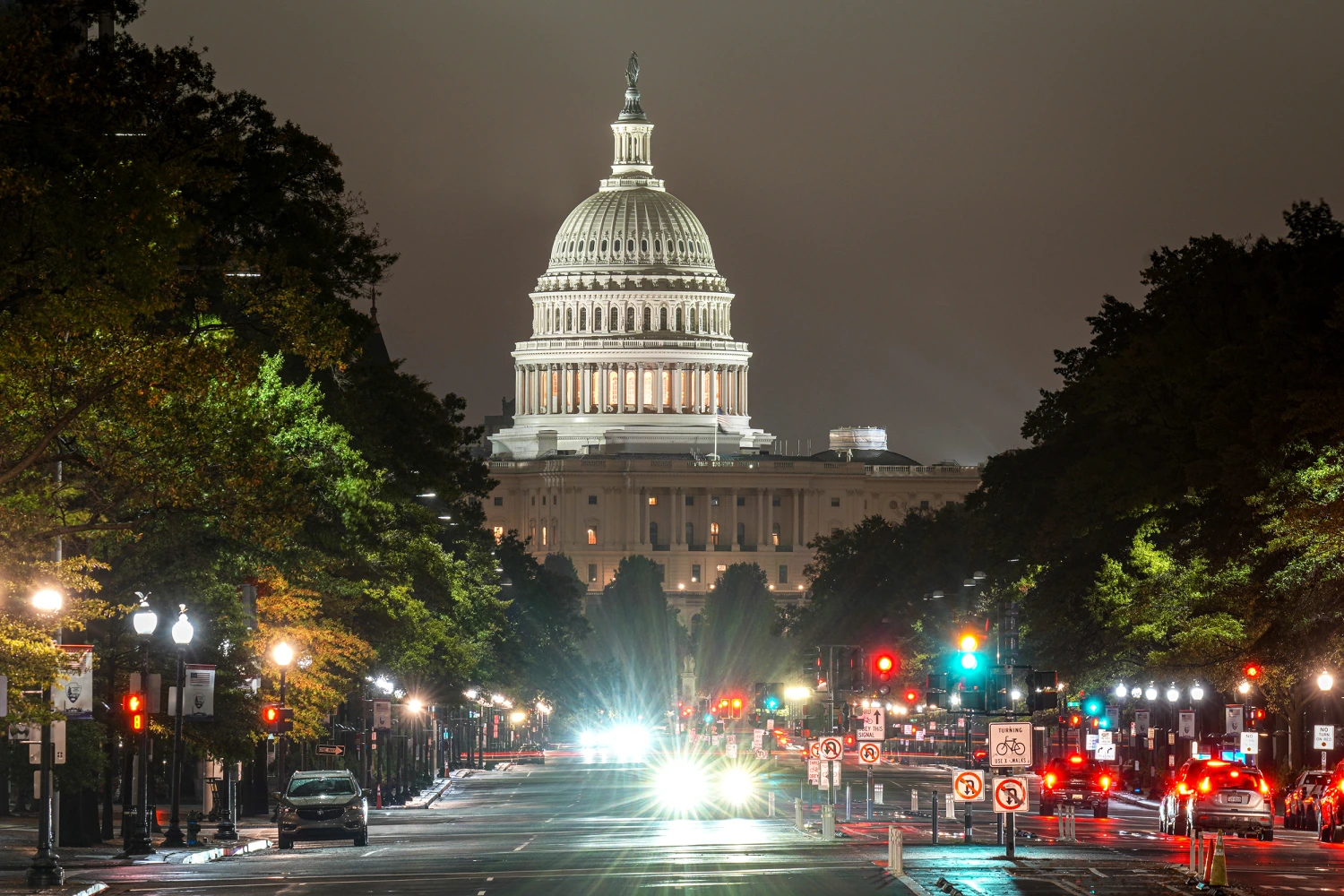 Traffic moves along rain slicked Pennsylvania Avenue at night with the U.S. Capitol Building in the background on October 11, 2026, in Washington, DC.