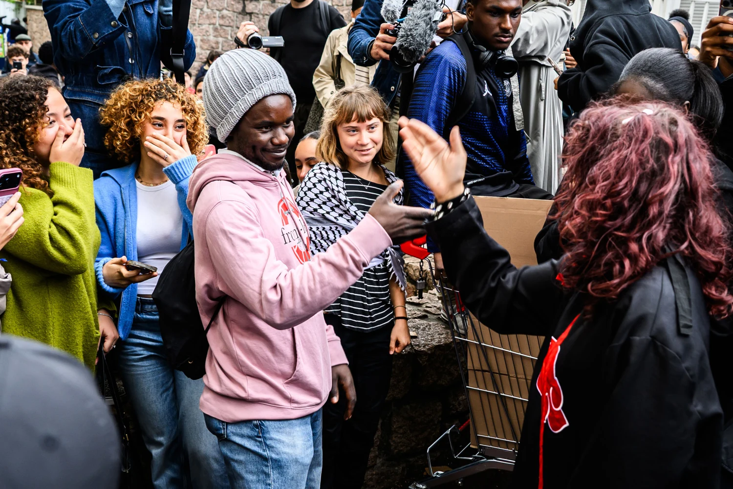 Greta Thunberg stands among demonstrators outside Paul-Éluard High School in Saint-Denis, France, amid a wave of youth mobilization across Europe.