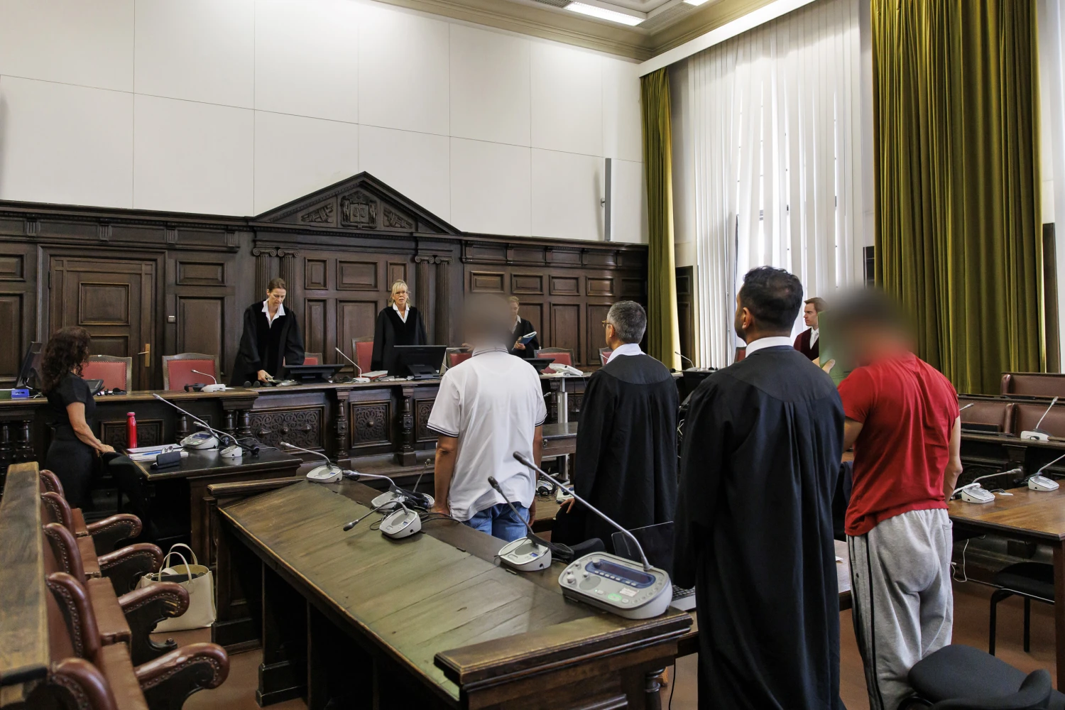 Defendants identified as Ali S. and Tawab M., faces obscured, at the opening of their trial on June 26, 2026 in Hamburg, Germany.