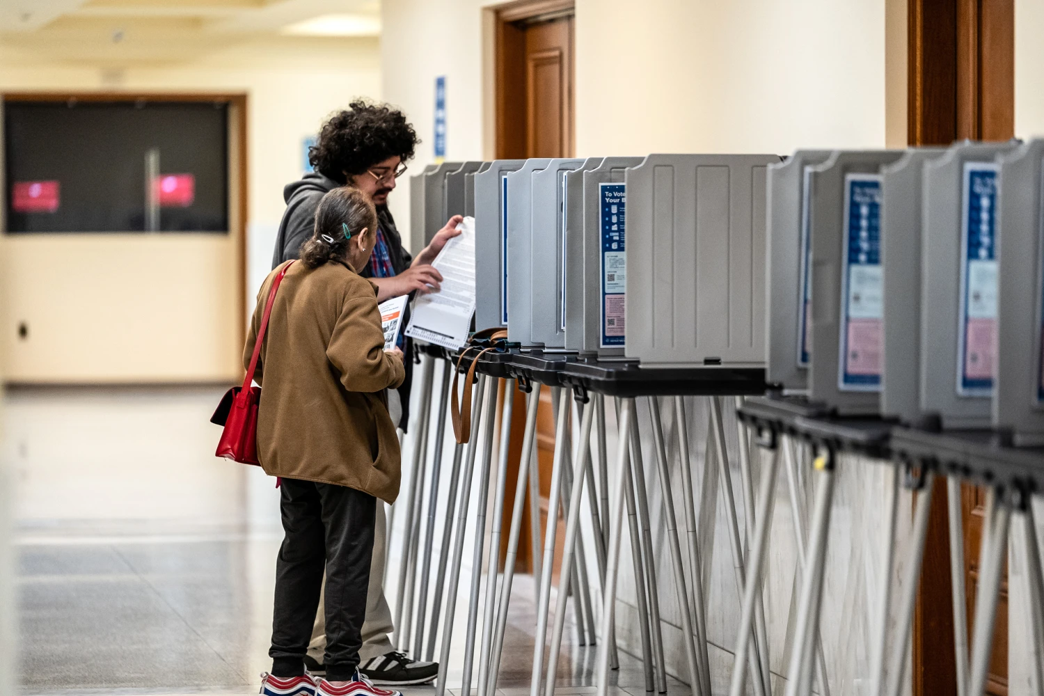 A poll worker assists a voter during early voting ahead of the midterm election inside City Hall in San Francisco on Oct. 8, 2026.