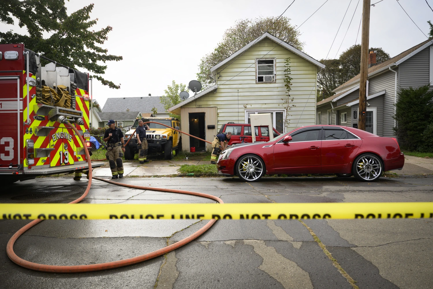 Firefighters clean blood on Oct. 10, 2026, from outside the home where 9 members of a family were killed in an apparent domestic dispute in Erie, Pa.