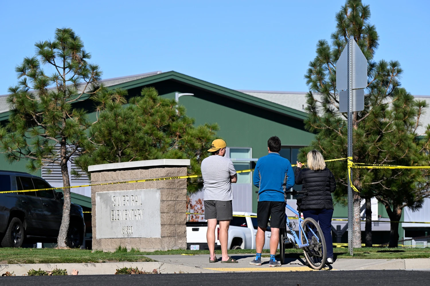 Onlookers stand outside Silver Rail Elementary school, where a shooting took place, on Thursday, Oct. 15, 2026 in Bend, Ore.