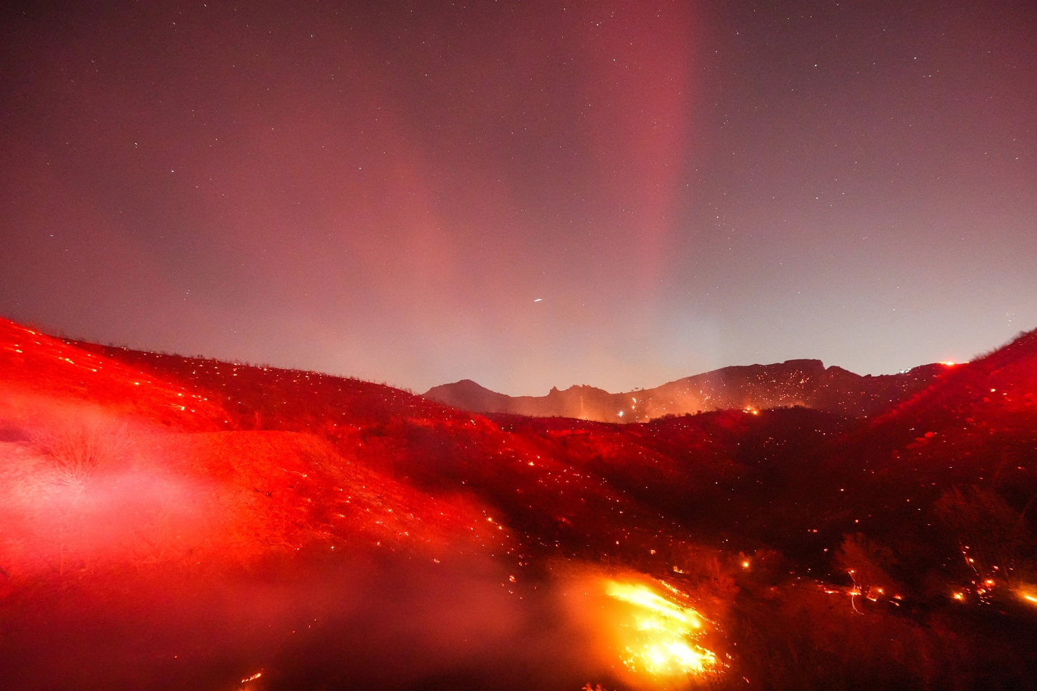 Hot spots glow across a hillside during the Bryson Fire in Malibu, Calif., Thursday, Oct. 15, 2026.