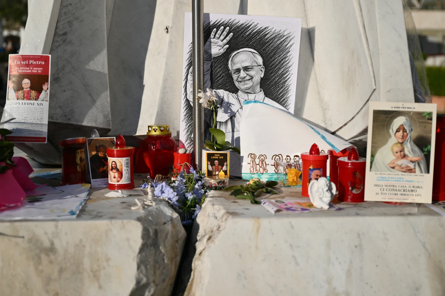 A drawing of Pope Leo XIV is laid at the statue of John Paul II outside the Gemelli University Hospital, where Pope Leo XIV is recovering after undergoing surgery to remove a cancerous tumour from his right lung.