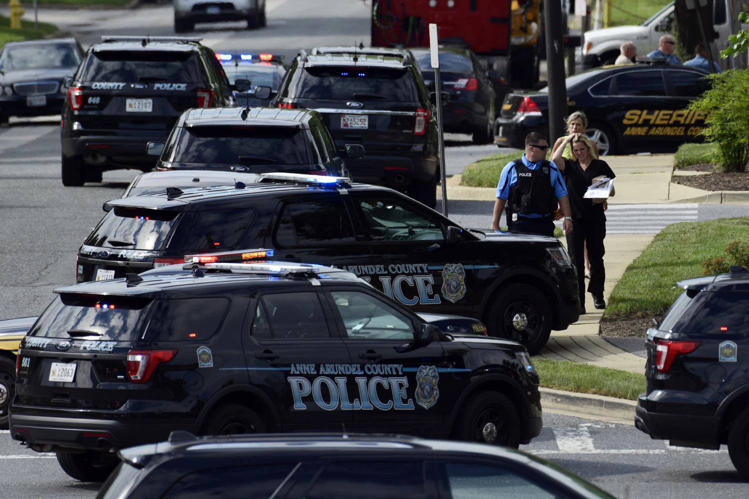 In this June 28, 2018 file photo, police secure the scene of a shooting at the building housing The Capital Gazette newspaper in Annapolis, Md. A county task force in Maryland that is studying ways to reduce gun violence in the wake of the 2018 killing of five employees at the local newspaper is scheduled to hear public comment for the first time. The Anne Arundel County Gun Violence Prevention Task Force is meeting Thursday evening, Aug. 15, 2019, in Annapolis, Md.
