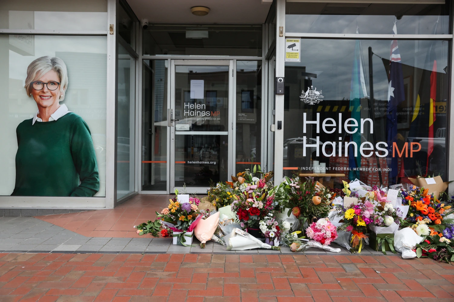 Floral tributes are placed outside the offices of Australian lawmaker Helen Haines who was critically wounded in a "targeted" attack, in Wangaratta on October 21, 2026.