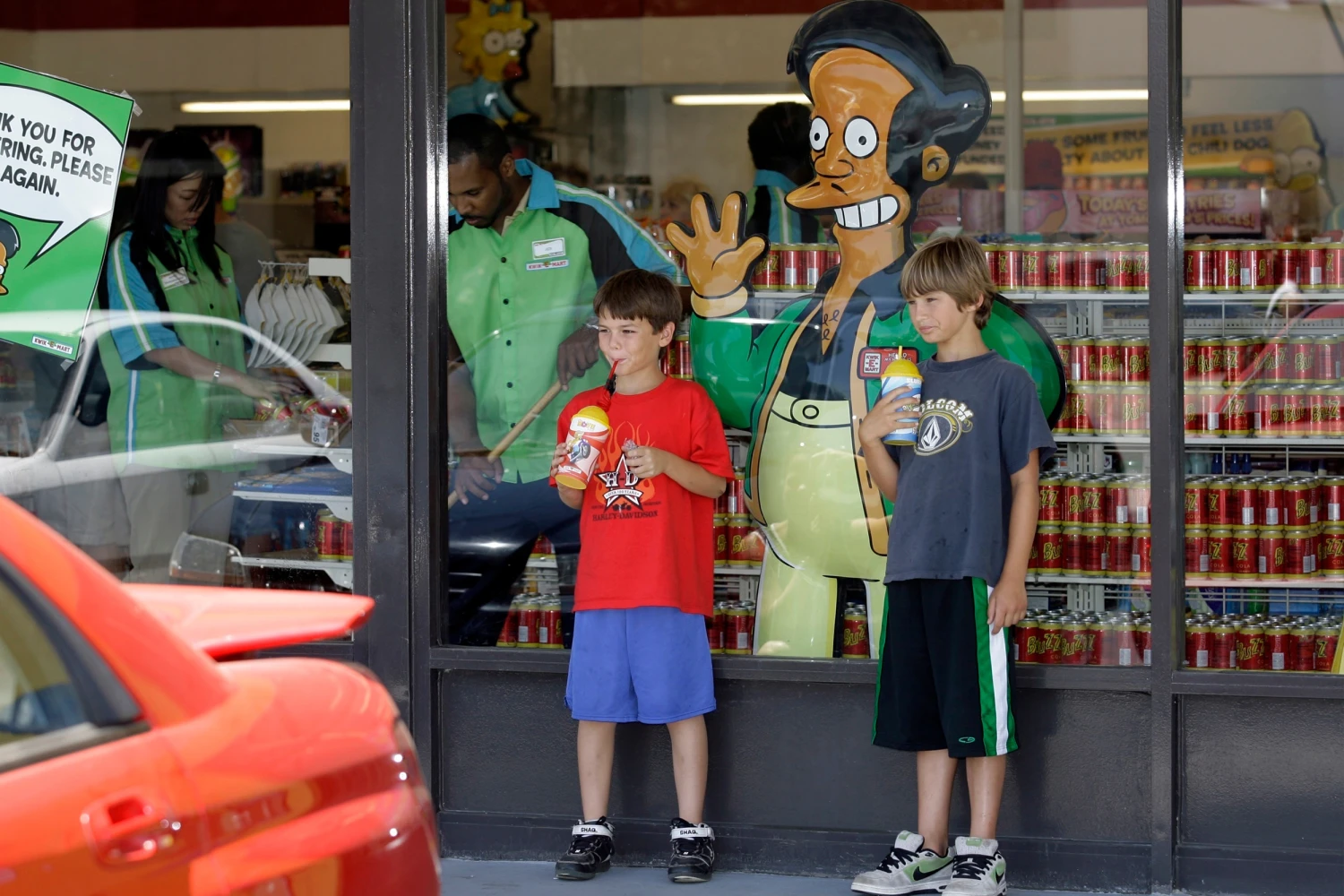 Children appear next to a window display featuring "The Simpsons" character Apu Nahasapeemapetilon Jr. outside a 7-Eleven Kwik-E-Mart in Burbank, Calif., on July 2, 2007.