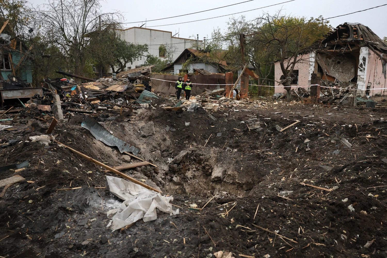 Ukrainian police officers stand next to a crater at the site of a missile strike in Kyiv on October 22, 2026, amid the Russian invasion of Ukraine.