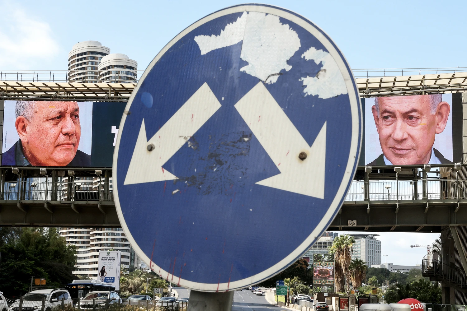 A road sign stands in front of a large billboard featuring Israel's Prime Minister Benjamin Netanyahu (R) of the Likud party and former military chief and leader of the centrist Yashar party, Gadi Eisenkot, in Ramat Gan on October 20, 2026.
