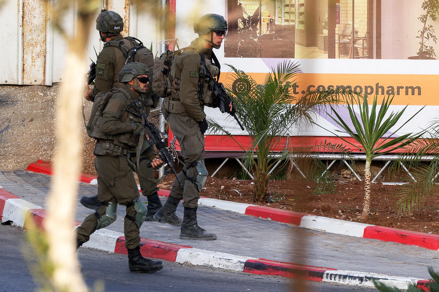 Israeli soldiers walk toward the bodies of two armed Palestinian men after a fire exchange at the northern checkpoint of Hebron on Friday.