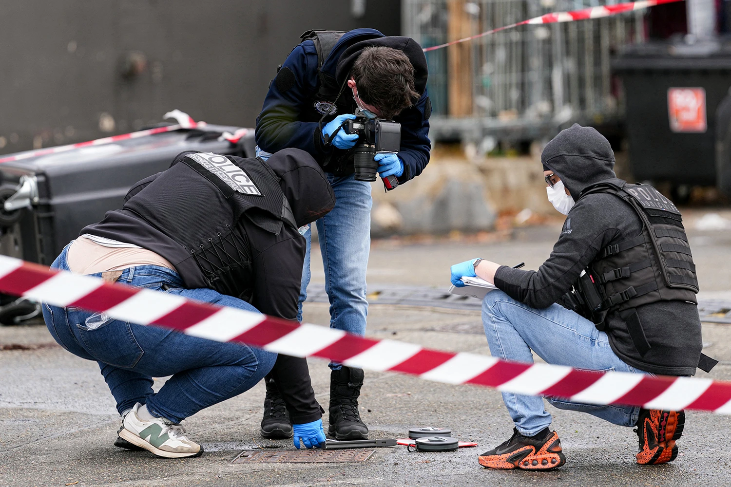 French police at the scene where a man opened fire from his car, killing one person and injuring four others in Trappes, a suburb of Paris on Friday.
