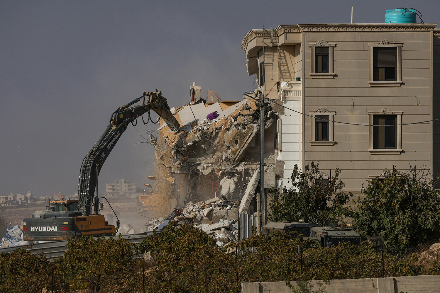 Israeli bulldozers demolish a Palestinian building in the West Bank city of Hebron on Oct. 23, 2026.