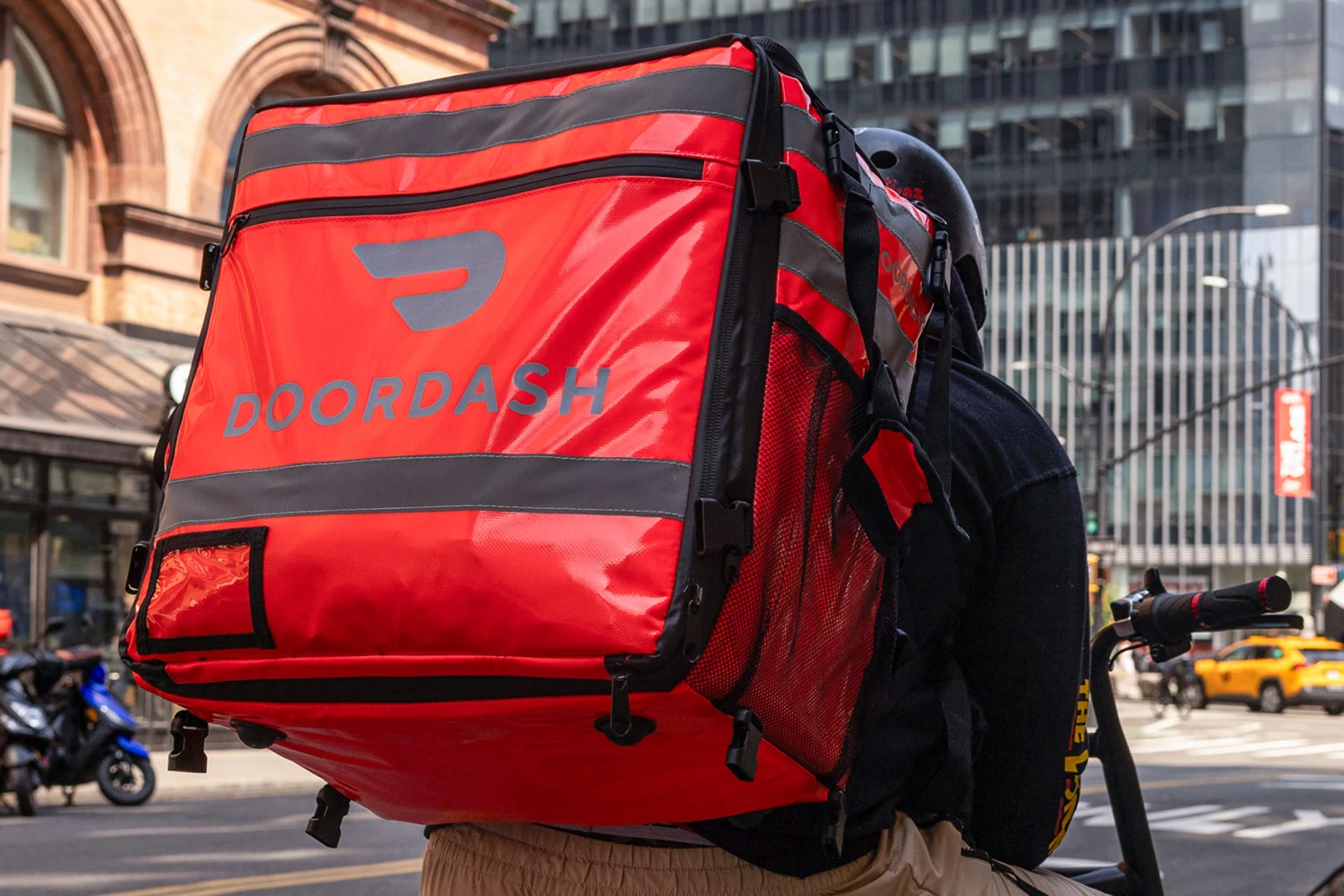 A delivery worker carries a DoorDash bag in New York City on April 29, 2024.